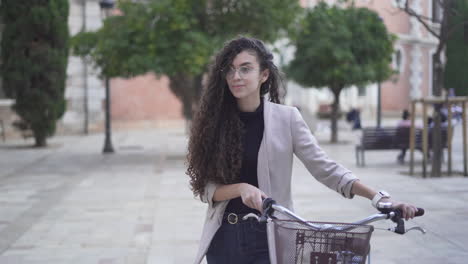 young woman walking with bicycle in the city