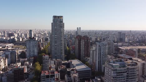 aerial approaching shot of large le parc skyscraper surrounded by high-rise buildings in downtown of buenos aires during sunset time