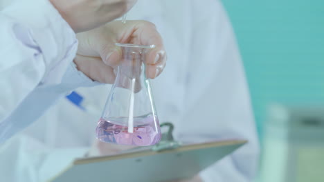 scientist holding a flask with liquid in a laboratory
