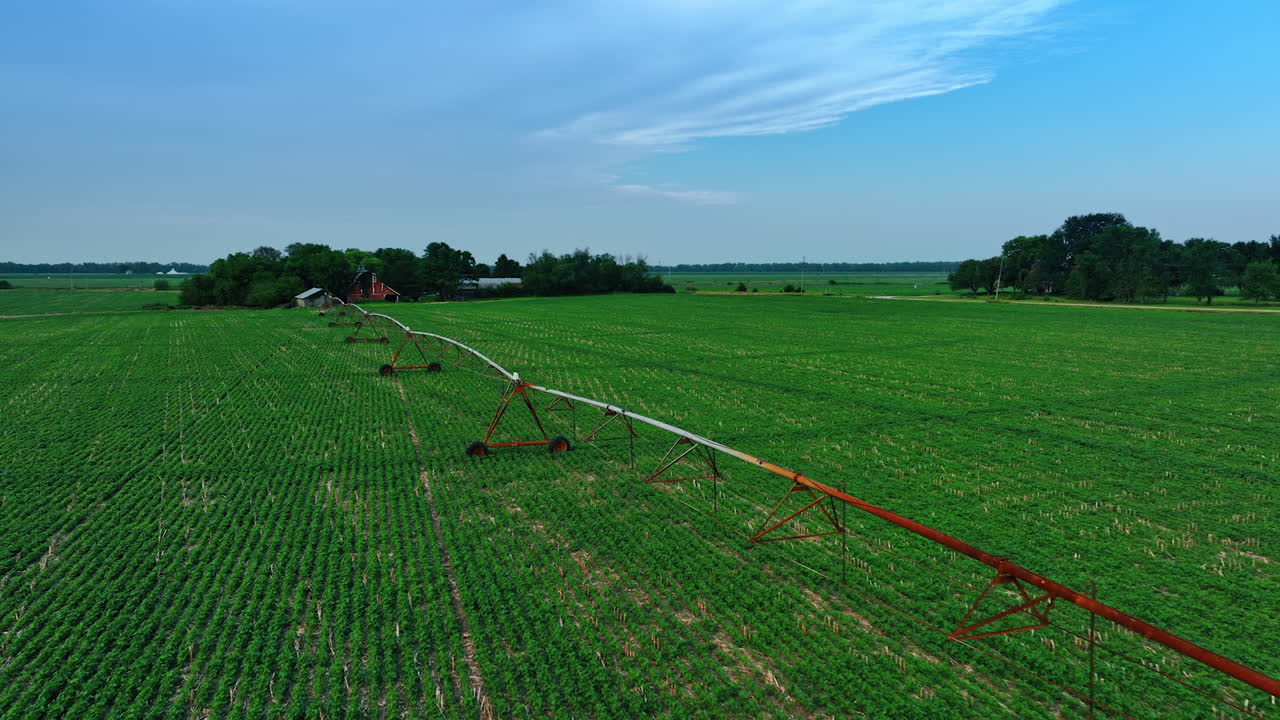 Flying over the green field with the irrigation system installed. Farming business concept. Aerial view.