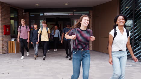 group of high school students walking out of college building together