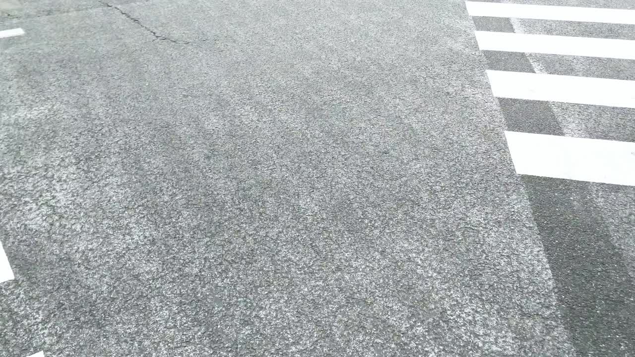 Japanese pedestrian crossing the street outside the famously crowded Shibuya station from point of view (POV) perspective high angle view in Tokyo, Japan.