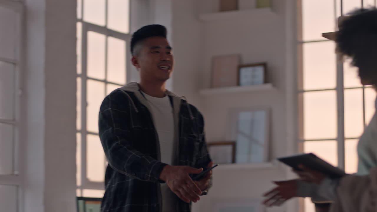 young asian businessman software developer meeting client shaking hands collaborating with intern on designing mobile application in office