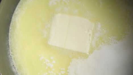 a butter cube melting inside a pot