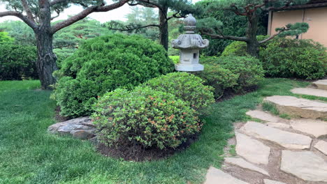 reveal of a japanese garden stone lantern outside in the afternoon
