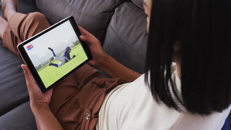 composite of woman sitting at home on couch watching baseball game on tablet