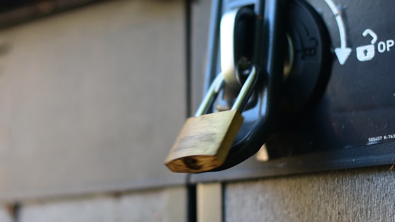 bellamente disparado extremo de cerca de un candado y pestillo en un cobertizo con las manos alcanzando para comprobar la cerradura y asegurarse de que está seguro, con estilo bokeh