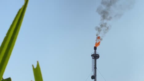 a gas plant's chimney burning gases and producing thick black smoke