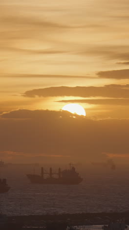 sunset over the ocean with ships