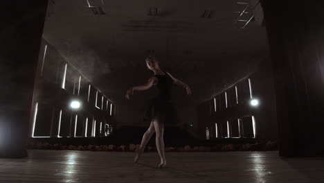 joven bailarina hermosa en el escenario de humo bailando ballet moderno. realiza movimientos suaves con las manos