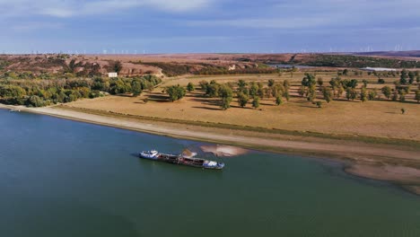 aerial wide shot of a dredger unloading dredged sand on a big river, sunny day