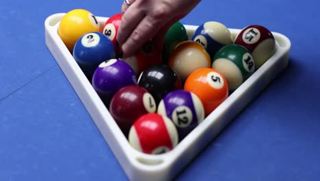 billiard balls racked on a blue pool table