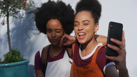 two mixed race women laughing on street