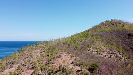 paisaje aéreo de cristo rey estatua de jesucristo bajando sobre montañas y colinas escarpadas con vistas al océano azul en dili, timor-leste