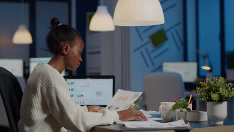 african business woman holding documents with graphics