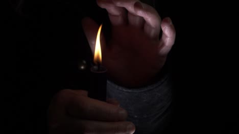 warming hands on candle flame medium shot