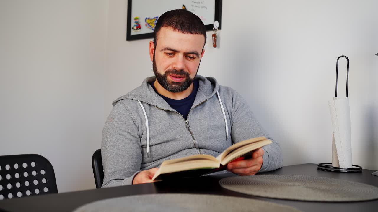 un hombre caucásico del medio oriente leyendo un libro en el interior - de cerca