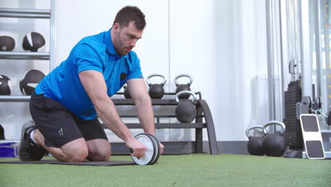 Hombre-Haciendo-Ejercicio-Con-Un-Rodillo-De-Abdominales-En-Un-Gimnasio.