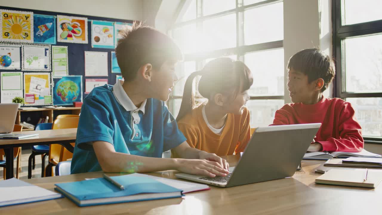 Video still of three children in a classroom, captured from a side angle