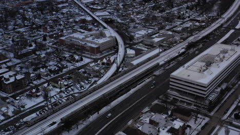 Una-Toma-Aérea-En-Los-Suburbios-Junto-A-Una-Zona-Industrial-Con-Vías-De-Tren-Y-Una-Autopista