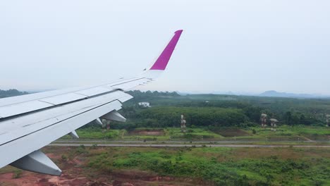 airplane descends over lush landscape to runway