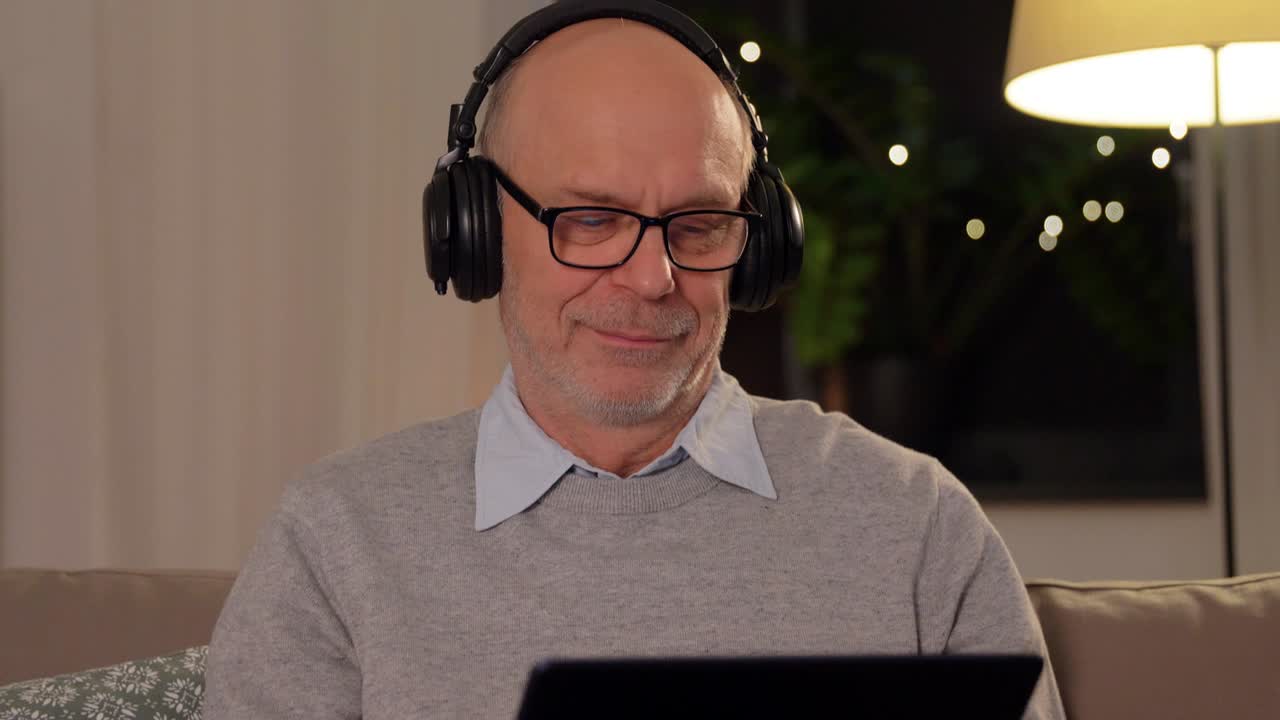 senior man with tablet pc and headphones at home