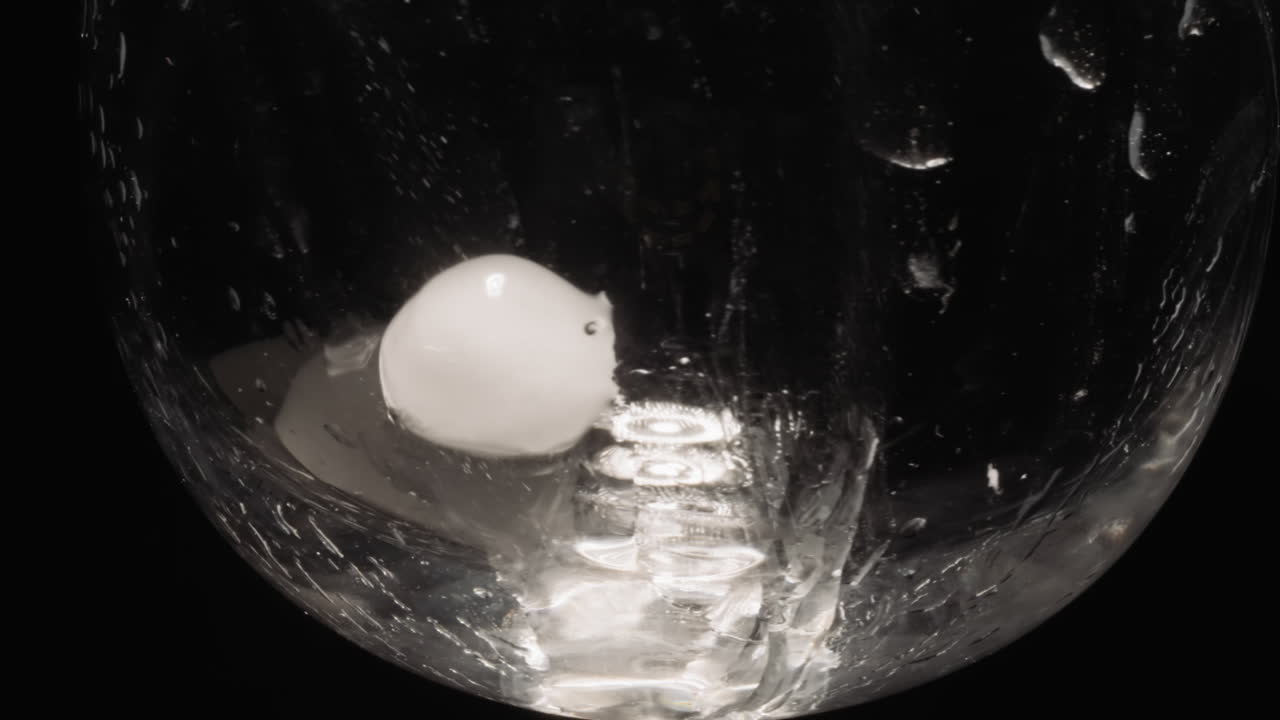 Cold ice cubes sliding and melting in transparent glass