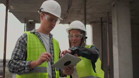 construction worker and engineer talking at construction site site. workers in helmets at building area. portrait of construction engineers working on building site. concept of modern construction