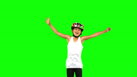 Cute-girl-wearing-a-bike-helmet-and-jumping-on-green-screen