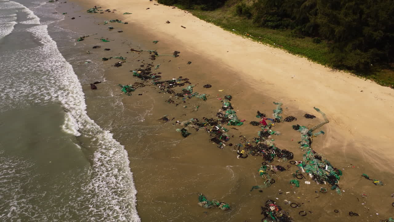 Aerial top down shot of dirt and waste at sandy beach after Typhoon Rai - orbit shot