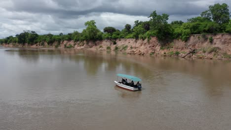 aerial drone shot orbiting around a boat in a river of selous, tanzania