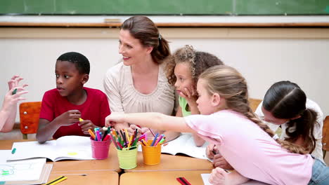 pupils and teacher sitting at a table