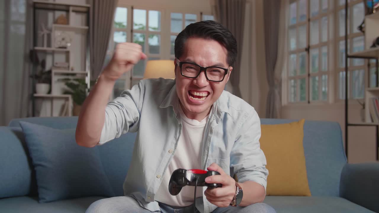 Young Asian  Man Gamer Cerebrate While Winning Video Game
