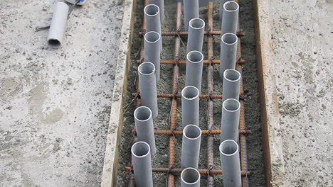 Wooden slab with PVC pipes placed on steel reinforcement mesh for construction
