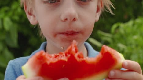 close up of a little boy enjoying a slice of juicy watermelon