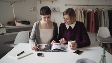 Two-woman-spend-leisure-together-and-reading-fashion-magazine