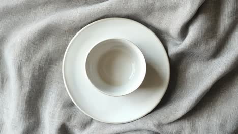 white plate and bowl on linen tablecloth