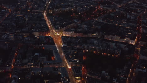 Birds-Eye-View-over-Berlin,-Germany-Neighborhood-at-night-with-glowing-street-traffic-city-lights,-Aerial-Top-View-Establishing-Shot