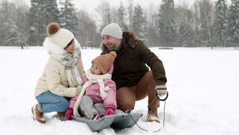 family sledding in the snow