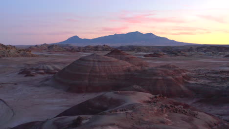 Drone-flying-past-man-in-colourful-rock-formations-at-Mars-desert-research-station-in-Utah,-United-States