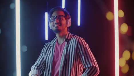 stylish man dancing with headphones in neon light