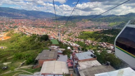 vista panorámica de la abarrotada ciudad de medellín desde la ventana de un teleférico