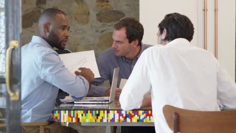 three men working together in a boardroom, slow motion