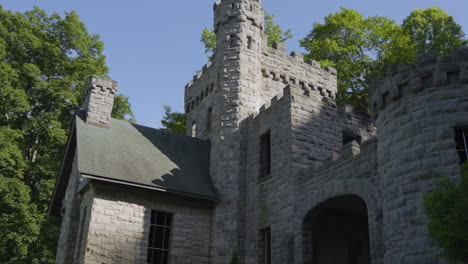 view of a beautiful stone castle tilting down from the battlement tower to the arched entryway