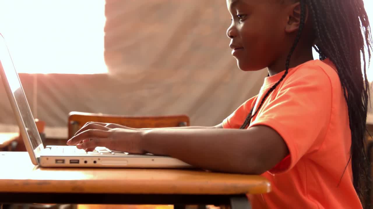 Little girl using laptop in classroom