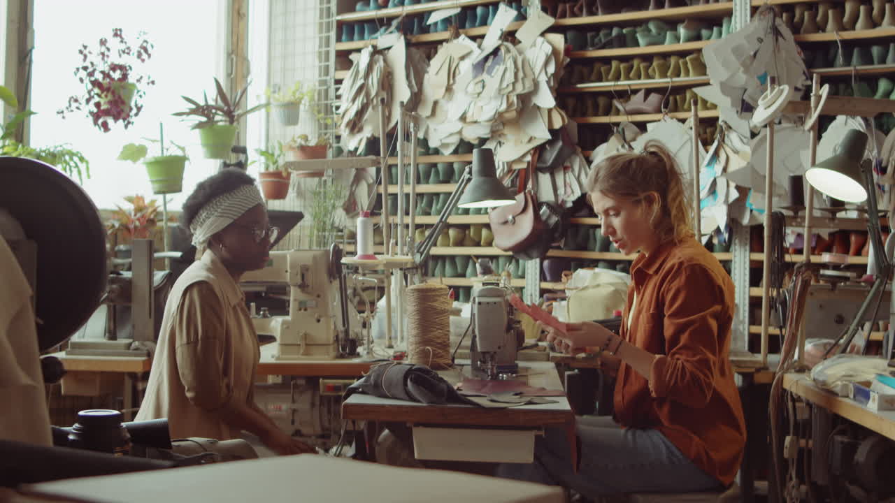 compañeras de trabajo discutiendo patrones de zapatos en el taller