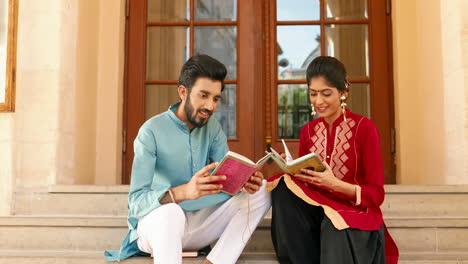 portrait of indian couple reading books and smiling