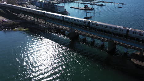 An-aerial-shot-of-an-NYC-subway-on-an-elevated-track-in-Queens,-NY