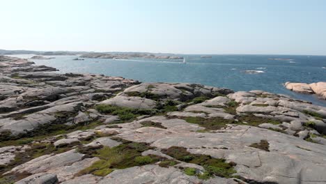 Drone-shot-flying-over-the-coast-of-Bohuslan-in-Sweden-with-boats-on-the-sea