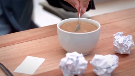 Casual-businessman-stiring-his-coffee